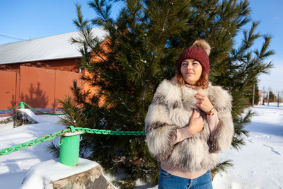Woman wearing fur coat standing outdoors during winter