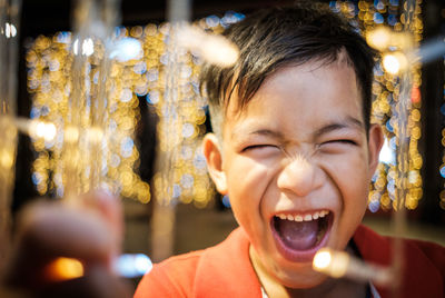 Close-up of boy shouting at night