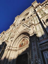 Low angle view of ornate building against clear blue sky