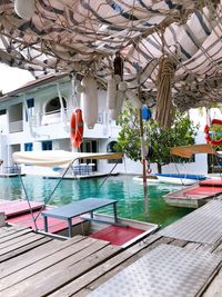 Lounge chairs by swimming pool against building