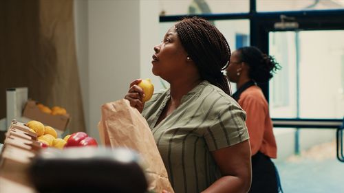 Side view of woman drinking juice at home