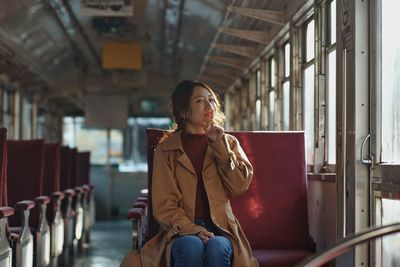 Full length of woman sitting on seat