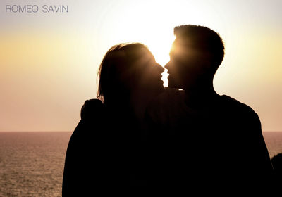 Silhouette people at sea against sky during sunset