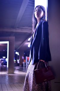 Young woman standing at night