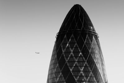 Low angle view of airplane flying in city