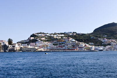 Town by sea against clear sky