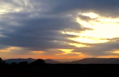 Scenic view of dramatic sky over silhouette landscape