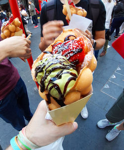 Midsection of people holding ice cream