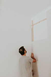 Rear view of man standing against wall