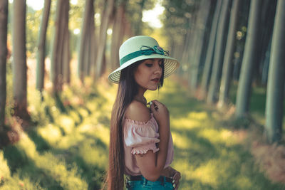 Side view of woman standing in forest