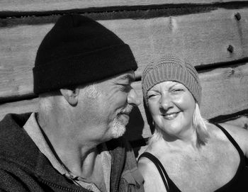 Close-up of mature couple sitting against wall