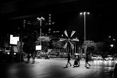 People in illuminated city at night
