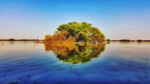 Scenic view of lake against clear blue sky