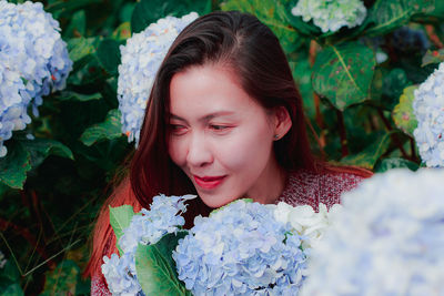 Mid adult woman by flowering plants in park