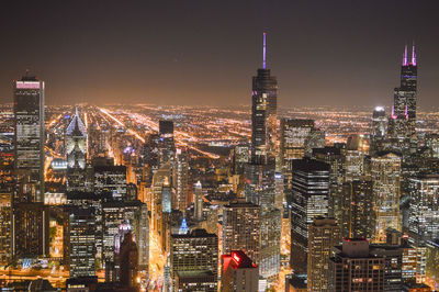 Illuminated cityscape against sky during night