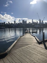 Pier on river with city in background