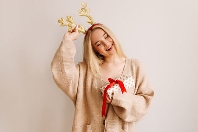 Young woman holding red flower against white background