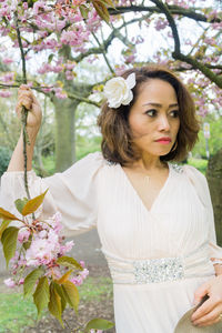 Portrait of young woman with pink flowers