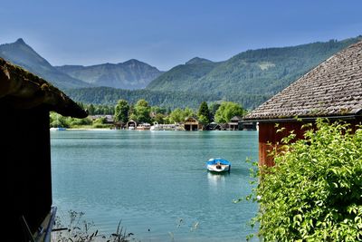 Rear view of woman sitting on boat in lake