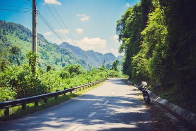 Road amidst trees against sky