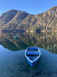 Boat in lake sylvensteinstausee against sky, bavarian alps, at nearly sunset