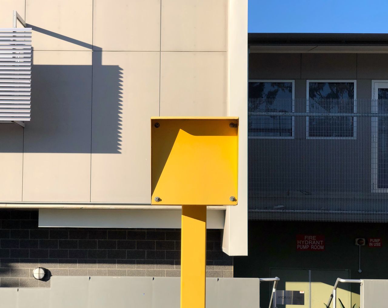 architecture, yellow, built structure, building exterior, no people, communication, sunlight, sign, building, outdoors, city, day, nature, shadow, metal, information, letter, wall - building feature, close-up, residential district