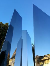Low angle view of modern sculpture against clear blue sky