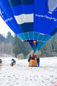 Hot air balloon on snow covered mountain against clear sky