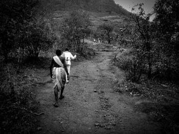 Rear view of man walking in forest