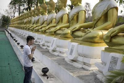 Side view of man standing in temple