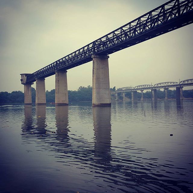 built structure, architecture, water, bridge - man made structure, connection, engineering, waterfront, river, bridge, sky, low angle view, travel destinations, architectural column, famous place, international landmark, tourism, travel, reflection, outdoors, no people