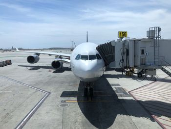 Airplane on airport runway against sky