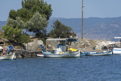 Sailboats moored on sea against sky