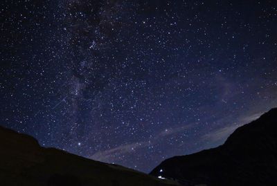 Low angle view of silhouette mountain against sky at night