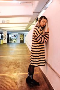 Portrait of woman standing against wall