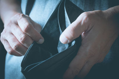 Midsection of man holding empty wallet