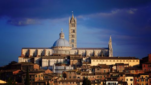 Low angle view of siena cathedral against blue sky