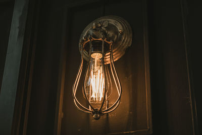 Low angle view of illuminated light bulb on door