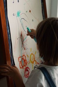 Rear view of boy drawing  at home