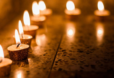 Close-up of illuminated candles on table