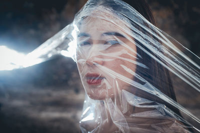 Close-up portrait of young woman covered in plastic