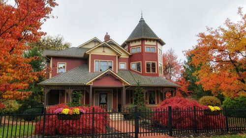 House by trees against sky during autumn