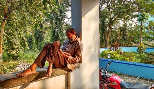 Side view of a man relaxing, sitting crossed leg with sunlight falling over him