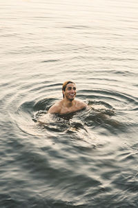 Portrait of shirtless man swimming in pool
