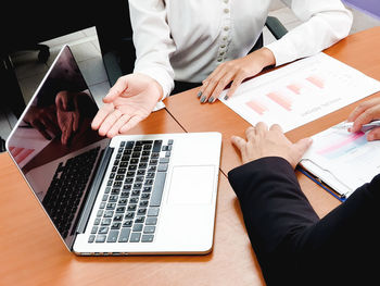 High angle view of people using laptop on table