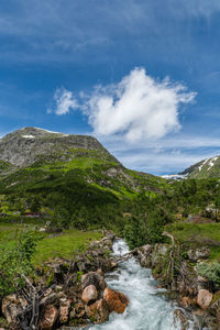 Wild stream between the mountains under a blue sky