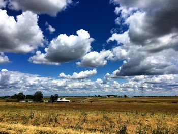 Scenic view of field against cloudy sky