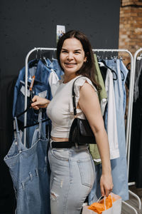 Young brunette latina attractive woman shopper choosing new jeans cloth at store.