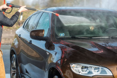 Reflection of man on car window on street