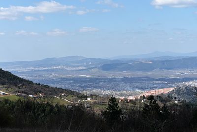 Aerial view of townscape and mountains against sky